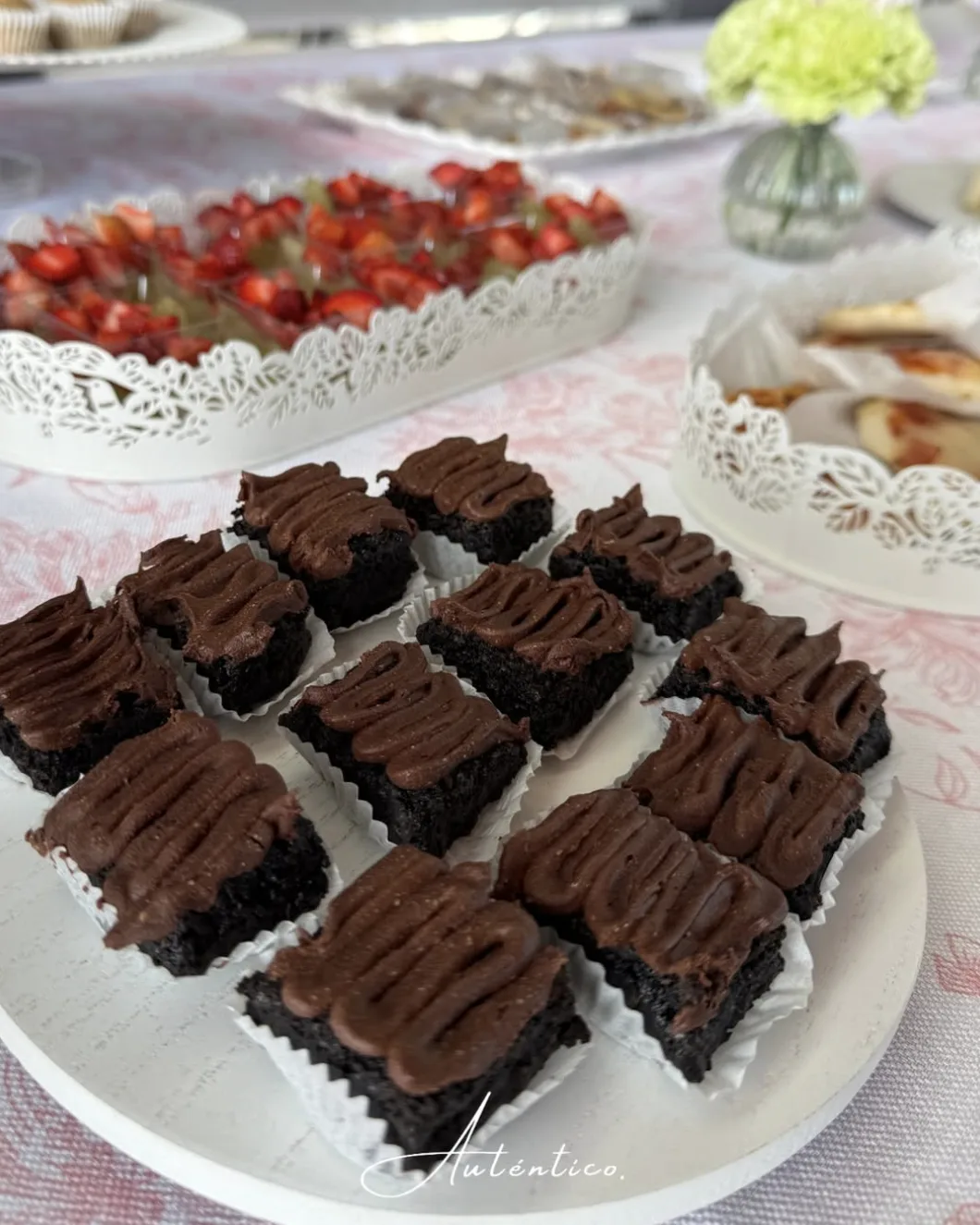 Brownies con cobertura de chocolate y brochetas de fruta preparados por AUTÉNTICO.